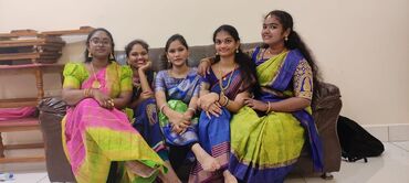 Two men in bicycle jerseys sitting outside at table having coffee