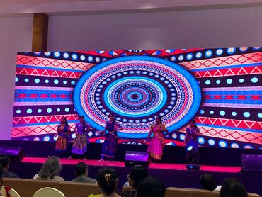 Two men in bicycle jerseys sitting outside at table having coffee