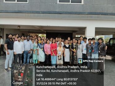 Two men in bicycle jerseys sitting outside at table having coffee